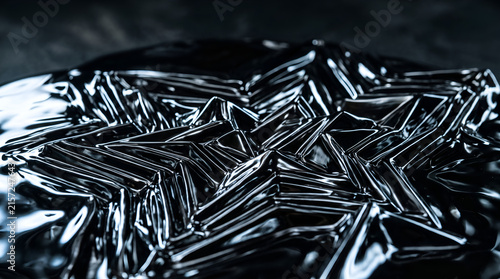 Abstract close up of glossy black liquid forming a star shape with reflections and ripples