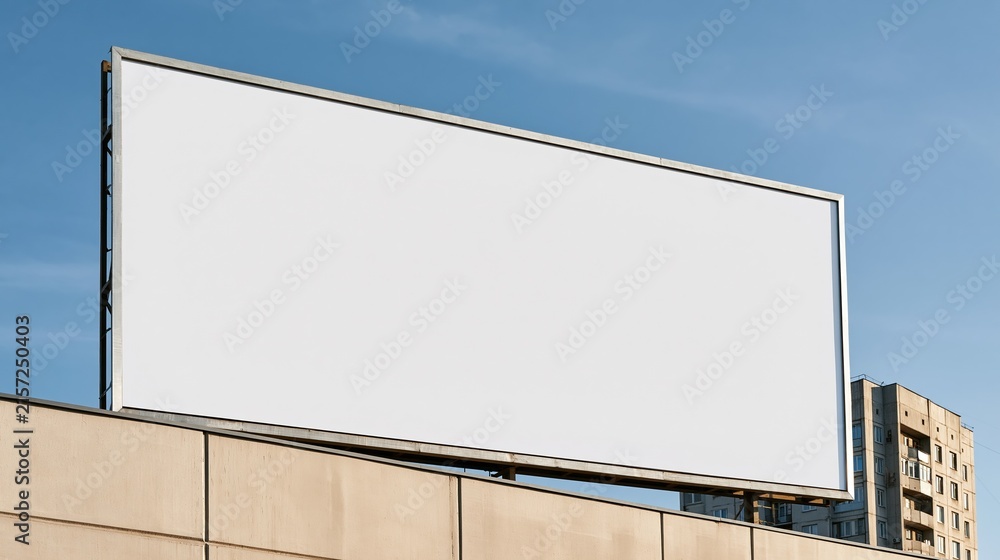 Fototapeta premium Blank Outdoor Billboard Sign on Building Rooftop Against Clear Blue Sky for Advertising