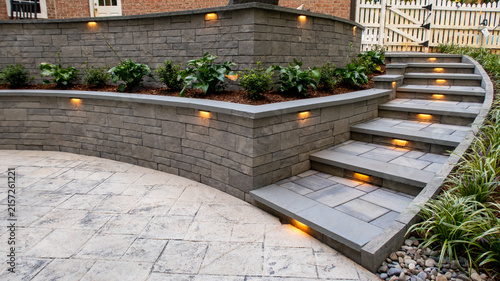 Canvas Print Custom Stone Retaining Wall With Integrated Cap Lighting And Tiered Patio Steps