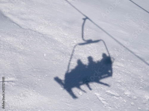 Silhouette d'une télécabine de ski se reflétant sur la neige immaculée, scène hivernale abstraite capturée sous un angle original et créatif