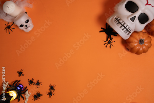 Fotografía A cheerful skeleton rests beside autumn leaves and miniature pumpkins against an orange background, creating a whimsical Halloween scene with generous room for text and graphic elements