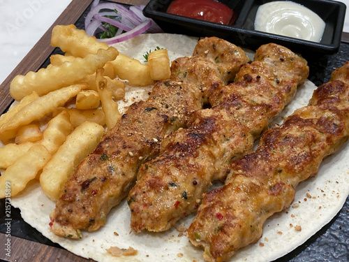 ラヴァッシュに乗ったチキンルラケバブ、ウェーブポテト付き中東料理プレート