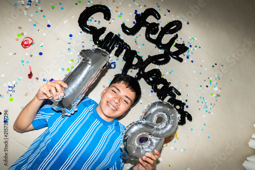 Photography Young man celebrating 18th birthday on floor with balloons