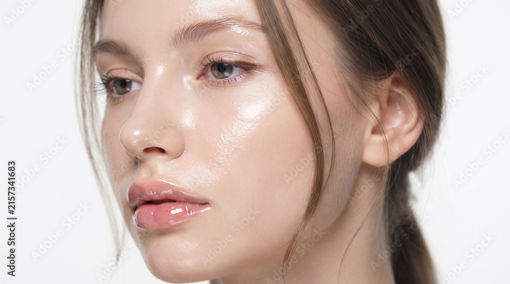 Fototapeta premium A Close Up Beauty Portrait Capturing the Moisture Rich, Wet Look Finish of the Skin, Highlighting the Natural Texture, Soft Peach Fuzz, and the Sparkle of the Catchlights in the Eyes