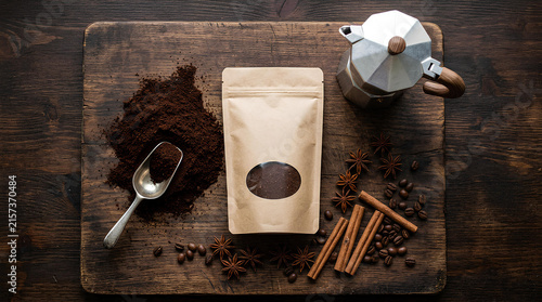 Coffee brewing ingredients and moka pot on wood board.