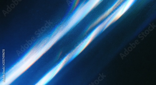 Abstract diagonal light streaks with prismatic color diffraction on a dark blue background