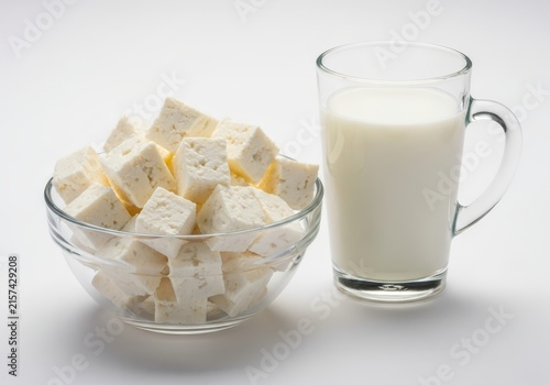 Fresh Paneer Cubes in a Glass Bowl and a Glass of Milk on White Background - Healthy Dairy Products