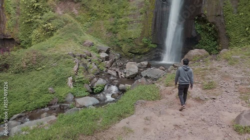 Serene Waterfall Oasis Surrounded by Lush Greenery and Boulders in a Peaceful Landscape