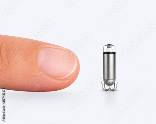 Obraz na płótnie Tiny leadless pacemaker beside fingertip for size comparison