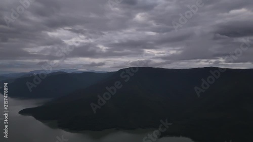 An aerial video showing the forest, mountains, and river in the morning.
