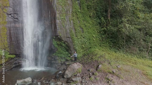 Captivating Scene of a Waterfall Surrounded by Lush Greenery and Boulders at the Nurtured Wilderness