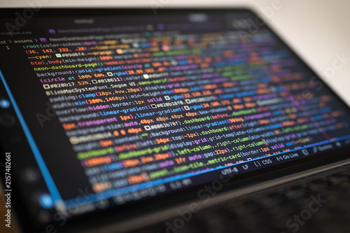 Software development code displayed on laptop screen with colorful syntax, representing web programming, frontend development, coding, debugging, digital technology and modern developer workflow.