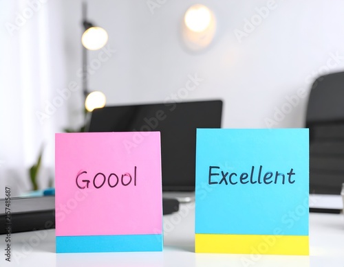 Hand-written good and excellent notes on pink blue paper.
