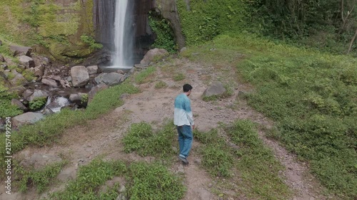 A Serene Adventure Beneath a Majestic Waterfall: Embracing Nature with Open Arms in Amazing Landscape