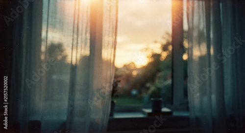 Soft Sunset Glow Through Sheer Curtains On A Window
