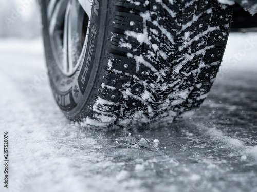Studded winter tire on snowy icy road surface