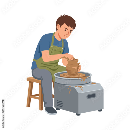 A young male potter working on a spinning clay pot using an electric pottery wheel in a workshop