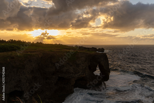 夕暮れ時の万座毛と断崖絶壁に差し込む夕日・沖縄県恩納村 the Manzamo cliff and ocean in Onna Village, Okinawa