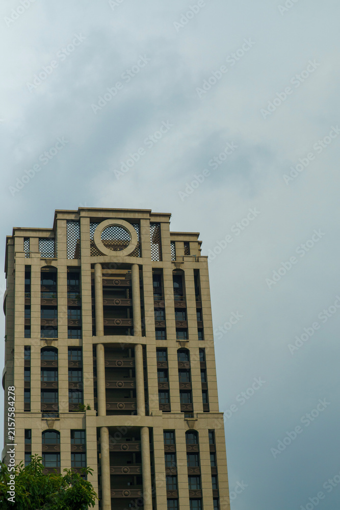 Fototapeta premium Distinctive cylindrical-topped office tower rising against a cloudy sky in Taipei, Taiwan