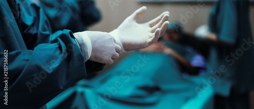 Surgeon putting on sterile gloves before operation in operating room, close-up of hands