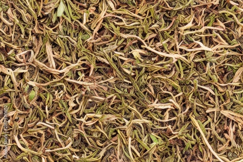 Tea leaves, ceramic cup, and green leaves