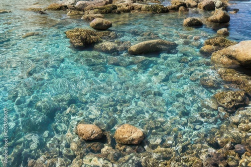 Clear blue water surface with smooth stones