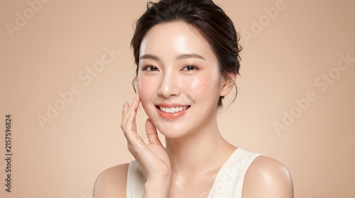 Beautiful young Asian woman with glowing clear skin touching face smiling for skincare beauty website banner portrait.
