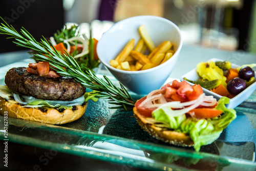 satisfying meal Beef Burger food photography art shot, potatoes, fries, salad, bread, transparent glass plate, photo selective focus with shallow depth of field. Taken at Sheraton Hotel, Cairo Egypt
