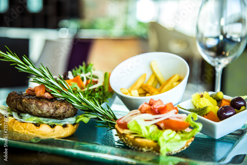satisfying meal Beef Burger food photography art shot, potatoes, fries, salad, bread, transparent glass plate, photo selective focus with shallow depth of field. Taken at Sheraton Hotel, Cairo Egypt