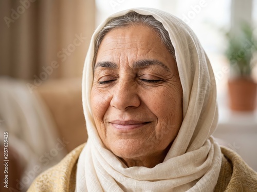 Peaceful elderly woman with eyes closed, wearing a headscarf