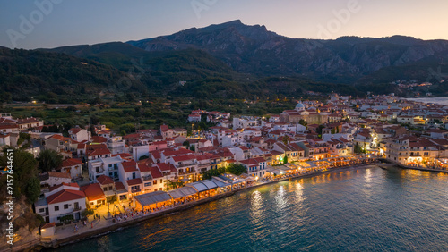Photography Aerial view of Greek island waterfront with bars and restaurants at dusk