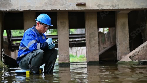 Water quality inspector collecting environmental samples from wastewater treatment infrastructure