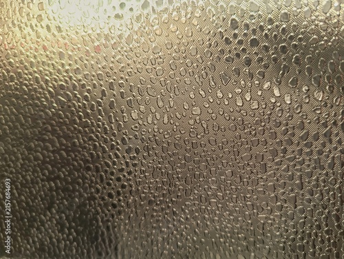 Фотография Close-up abstract surface covered with numerous water droplets, creating a detailed wet texture with natural highlights and reflections, suitable for backgrounds and texture design