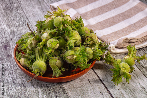 Fotografía Fresh green hazelnuts or cobnuts in wooden bowl on rustic table