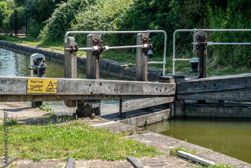 Wooden canal lock gates with safety instruction marking the cill position for boats on an English waterway.
