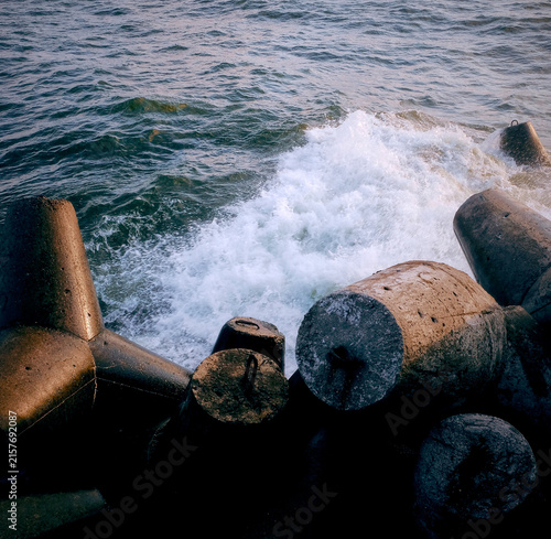 Картината върху платно Waves crashing against concrete breakwater at the seaside