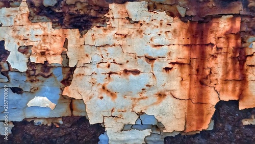 Close-up abstract texture of an old weathered surface with cracked and peeling layers. Natural grunge background showing aged, rough, damaged, and deteriorated patterns.

