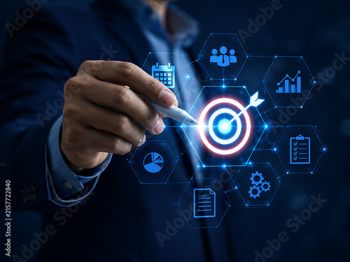 Business strategy concept with a hand touching a glowing target and data analytics interface