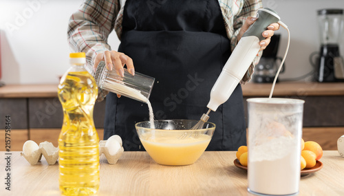 Konstfotografi Pastry chef adds sugar to eggs in a glass bowl and whisks them with an immersion blender attachment