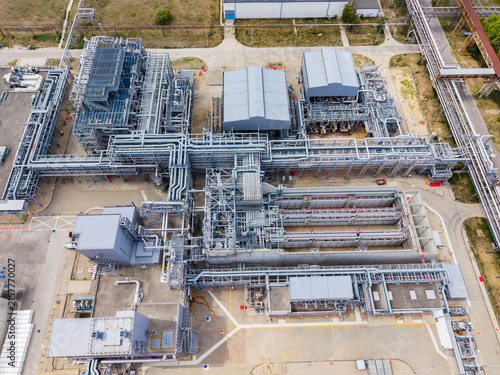 Facility shows a network of pipes and buildings during the day at a manufacturing site in an industrial area