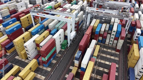 Gantry cranes moving shipping containers at a port terminal