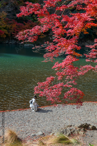 Japanese girl in kimono enjoy autumn falling leaf at Katsura river, Arashiyama