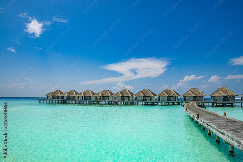 Naklejka premium Luxury overwater villas turquoise ocean lagoon tropical island resort blue sky paradise. Perfect summer vacation travel landscape. Exotic Maldives hotel honeymoon getaway relax scenic backdrop