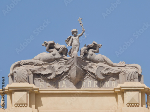 Bild auf Leinwand Sculptural relief pediment on the Regia Dogana historic customs house building featuring mermaids and child figure with caduceus staff in Messina, Sicily, Italy