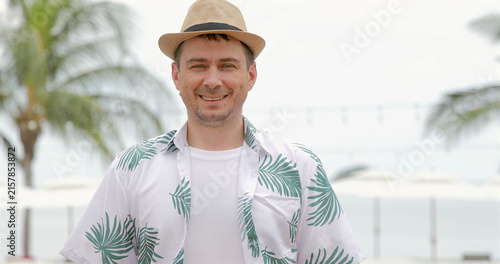 Photography Smiling man wearing straw hat tropical shirt, beach background, summer vacation concept, casual travel attire, outdoor leisure, relaxation, lifestyle
