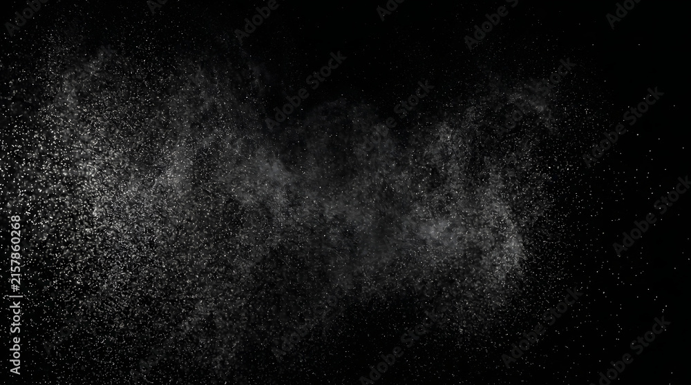 Obraz premium Fine white dust particles bursting against a solid black background creating dynamic texture