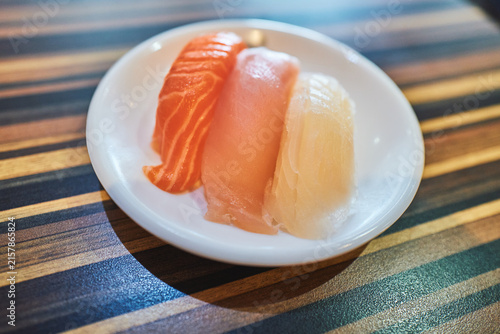 Three sashimi slices on a round plate from above