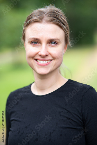 Beautiful Young smiling Woman in Black Top and Jeans Posing Outdoors