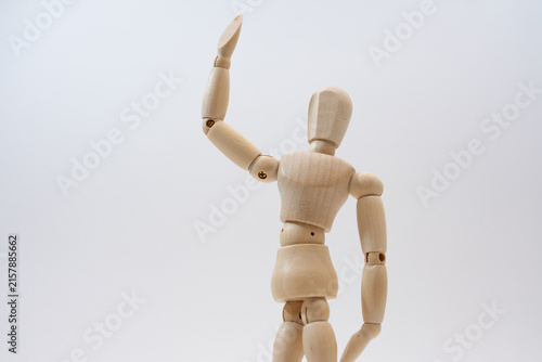 手を挙げる木の人形