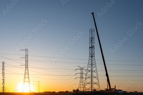 Transmission Tower Construction with Mobile Crane at Sunset